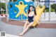 A woman in a blue bathing suit sitting on a yellow slide.