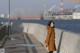 A woman standing on a pier next to a body of water.