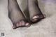 A close up of a woman's feet in black stockings.