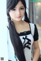 A woman with long black hair wearing a maid outfit.