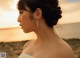 A woman in a wedding dress standing on a beach.