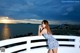 A woman in a blue and white dress standing on a balcony.