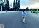 A woman walking down a street with her back to the camera.